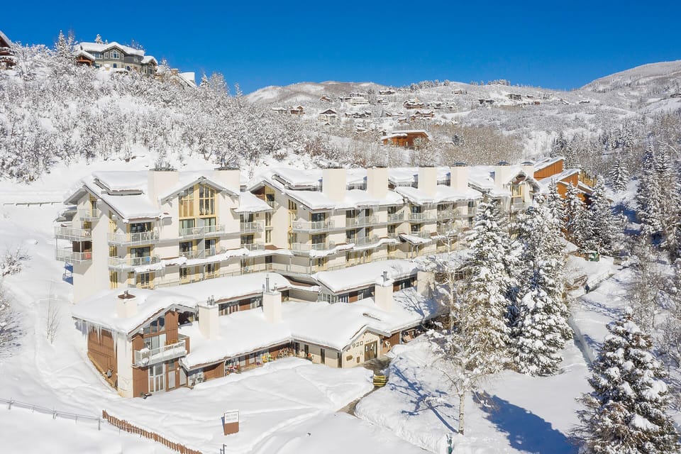 A snow-covered Alpine resort nestled in a picturesque mountain valley, surrounded by frosted evergreens and traditional chalets, offering a scenic winter retreat with pristine slopes nearby.