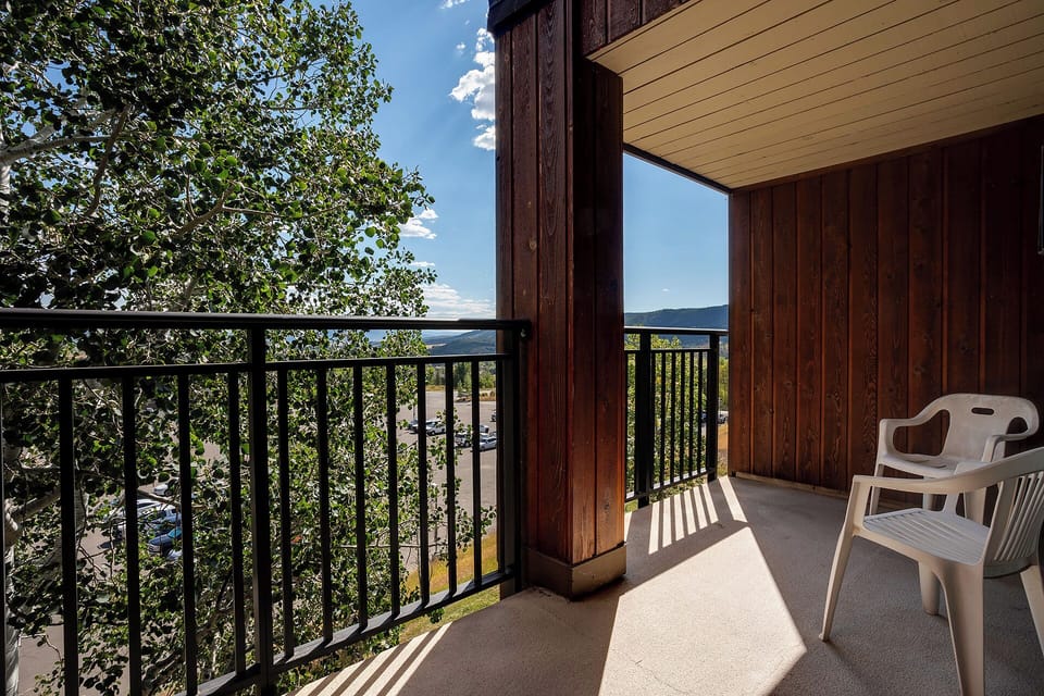 Step onto your private balcony where warm sunlight filters through lush trees, creating peaceful shadows while you enjoy serene valley views.