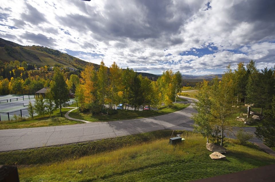 Scenic mountain valley setting with autumn foliage and winding roads leading to the property area.