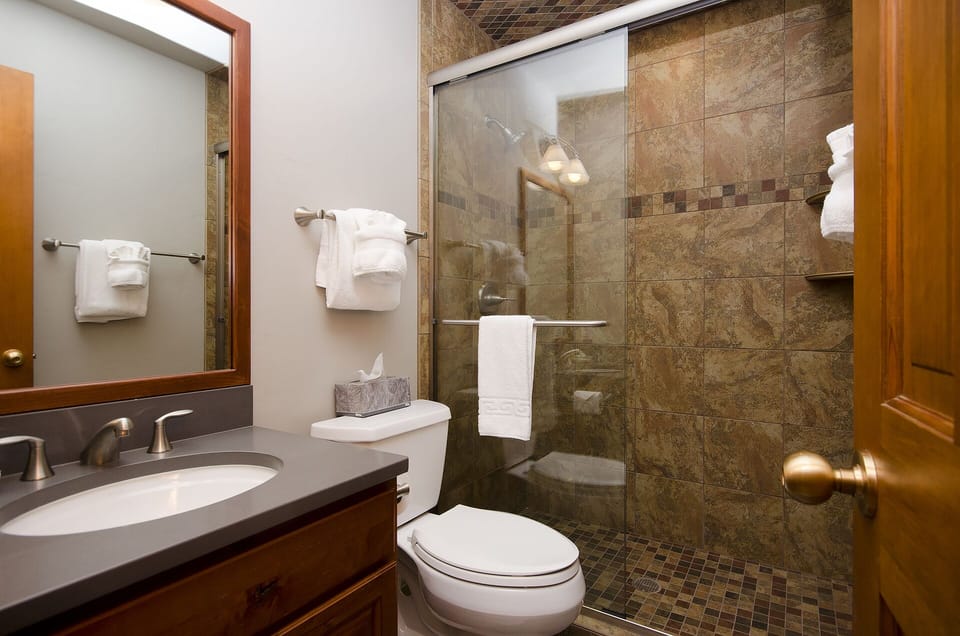 Refresh after your adventures in this beautifully appointed bathroom with elegant stone tile, walk-in shower, and plush towels awaiting your arrival.