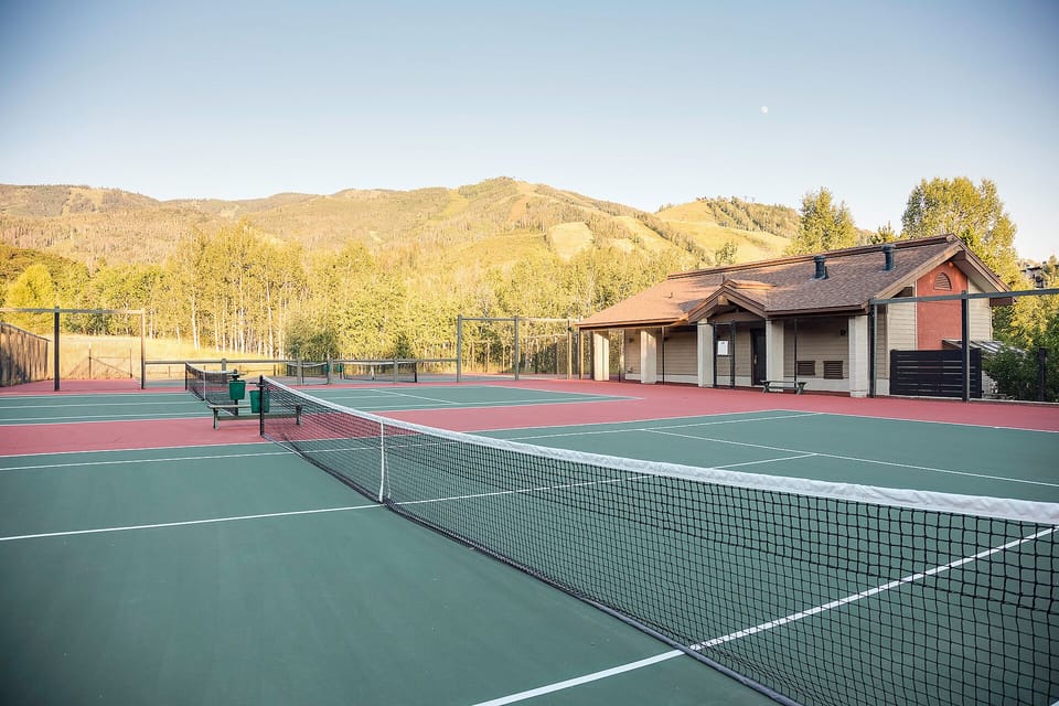 Multiple tennis courts backed by scenic mountain views and golden aspens, offering an ideal outdoor setting for friendly matches and active leisure.