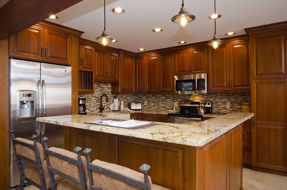 Cook your favorite meals in this fully-equipped gourmet kitchen featuring granite countertops, stainless steel appliances, and a spacious breakfast bar.