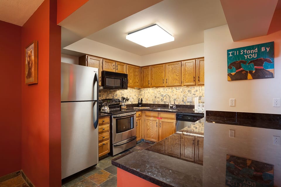 Your fully equipped kitchen features granite countertops, stainless appliances, and warm wood cabinets—perfect for cooking memorable meals together.