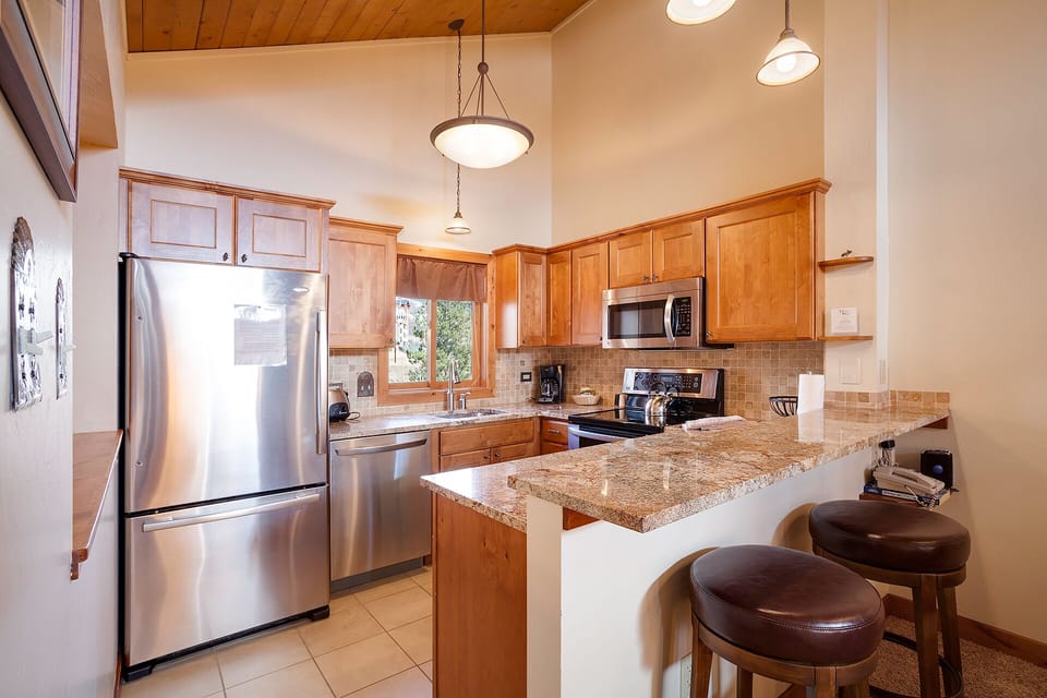 Your fully equipped kitchen features granite counters, stainless appliances, and a breakfast bar where you can enjoy morning coffee.
