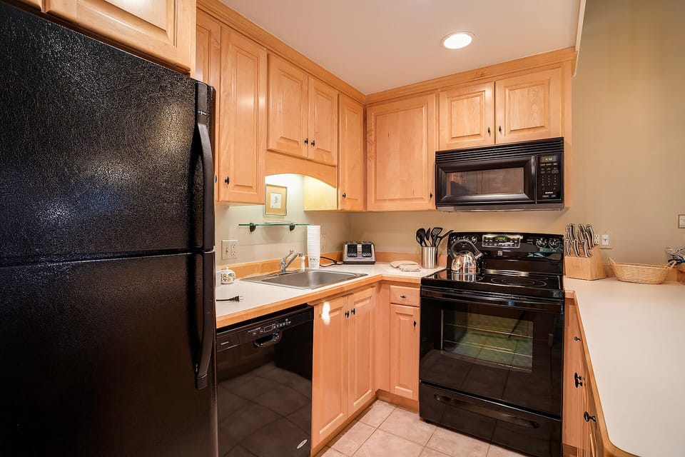 Your fully equipped kitchen awaits with warm wood cabinetry, full-size appliances, and all the essentials for preparing memorable meals during your stay.