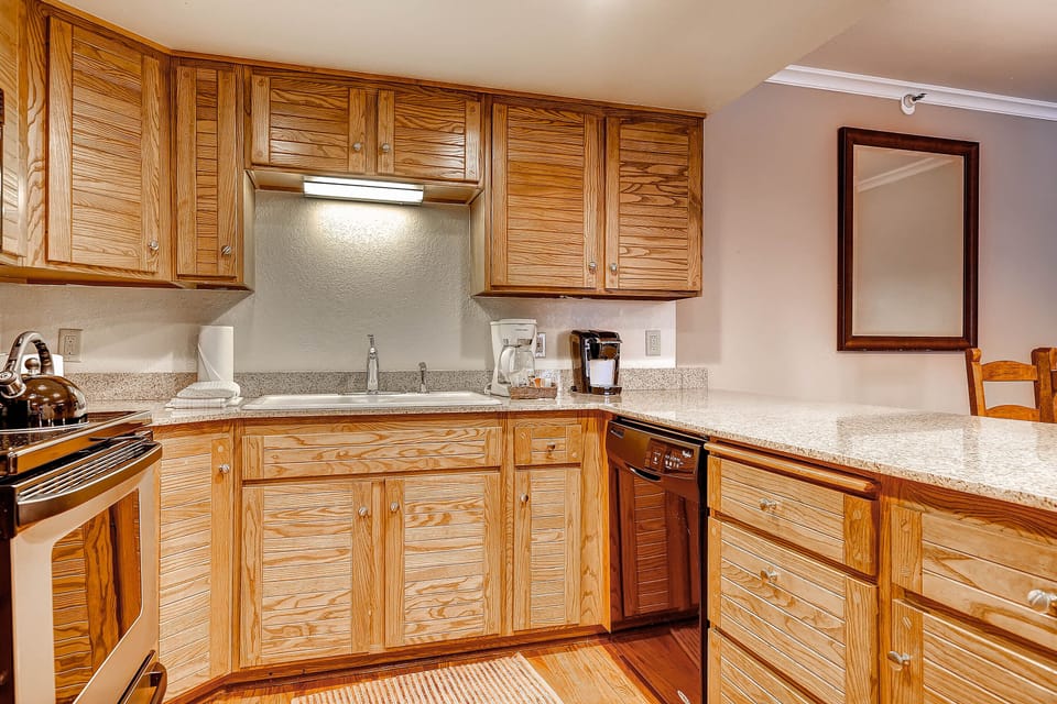 The well-equipped kitchen offers stainless steel appliances and wood cabinets.