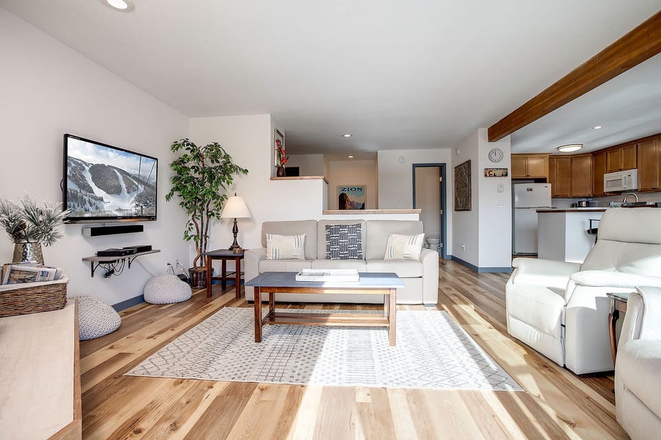 Relax in your bright, open living space with cozy seating, mountain views on the big screen, and everything you need in the adjoining kitchen.