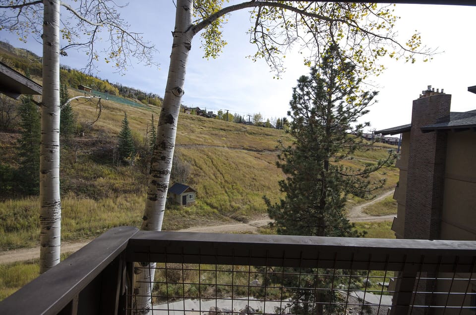 Your private balcony overlooks rolling hills dotted with aspens, where golden autumn light filters through leaves and mountain breezes whisper promises of peaceful mornings.