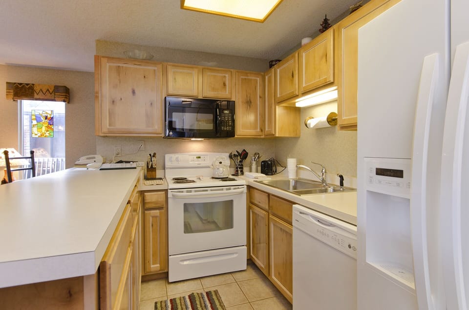 Your fully equipped kitchen features warm wood cabinets, modern appliances, and everything you need to prepare meals during your stay.