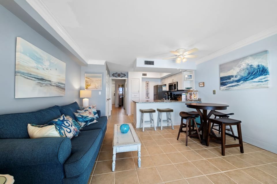 Unwind in your coastal-inspired living space with ocean-themed artwork and comfortable seating that flows into your fully equipped kitchen.