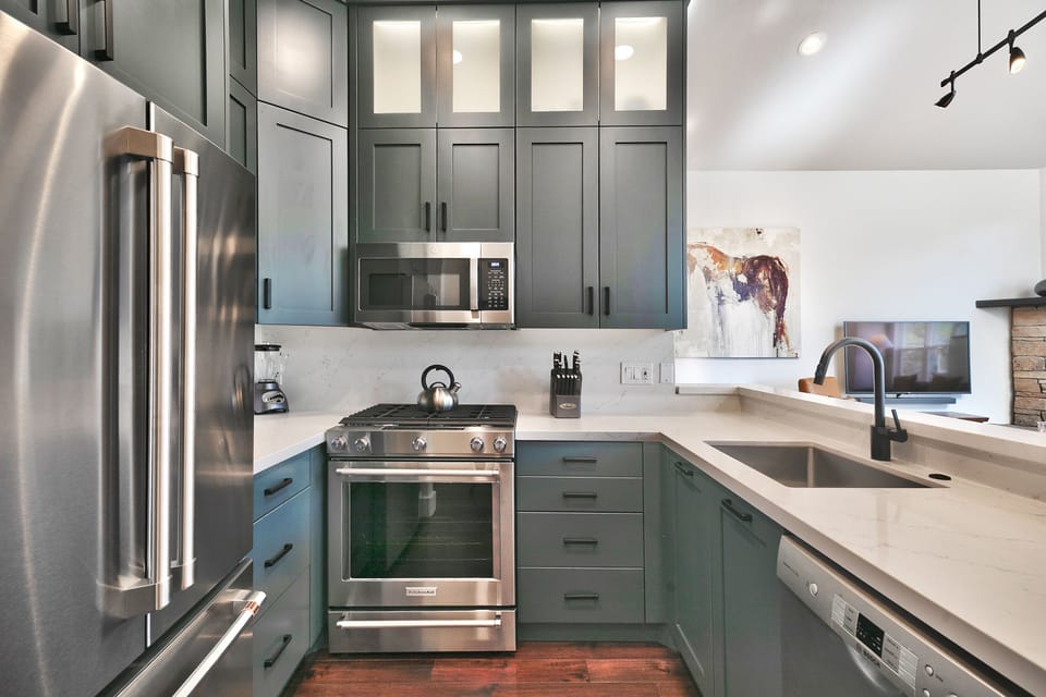 Fully equipped kitchen with French door refrigerator, gas range, and stainless steel appliances