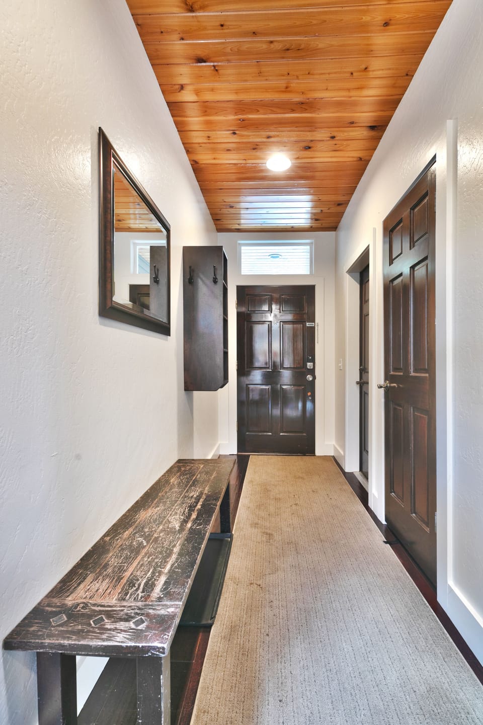 Woodside Haus entryway with wooden bench and carpet runner
