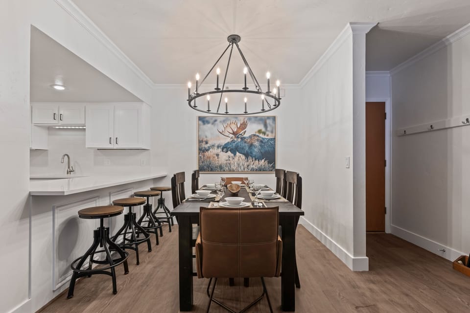 The dining table has 6 chairs, beautiful chandelier and moose artwork.