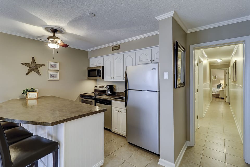 Kitchen and dinning area - The newly renovated Kitchen / Dining Area features all stainless appliances, granite counters and dining bar having seating for four, and tile flooring throughout.