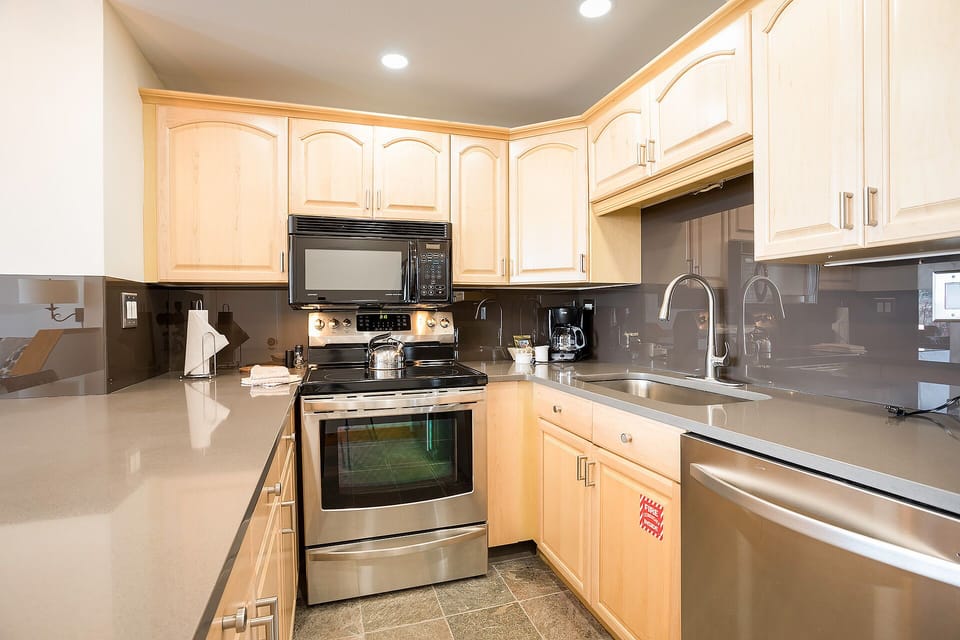 Your fully-equipped kitchen awaits with gleaming granite counters, stainless steel appliances, and warm wood cabinets for all your culinary adventures.