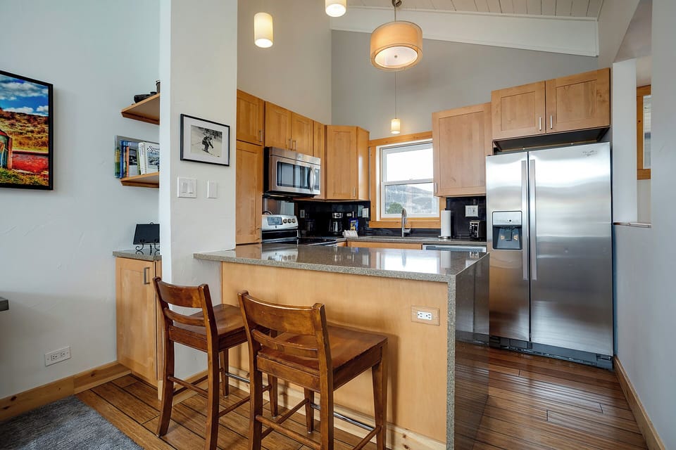 Cook your favorite meals in this modern kitchen featuring granite countertops, stainless steel appliances, and a breakfast bar perfect for morning coffee.