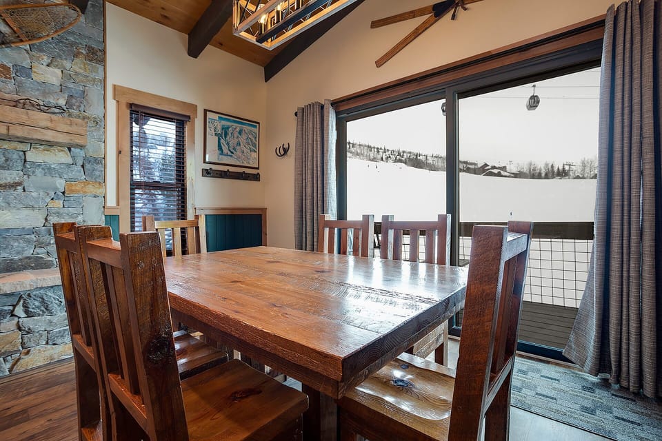 Gather around this rustic wooden dining table where you'll share meals with mountain views through expansive windows.