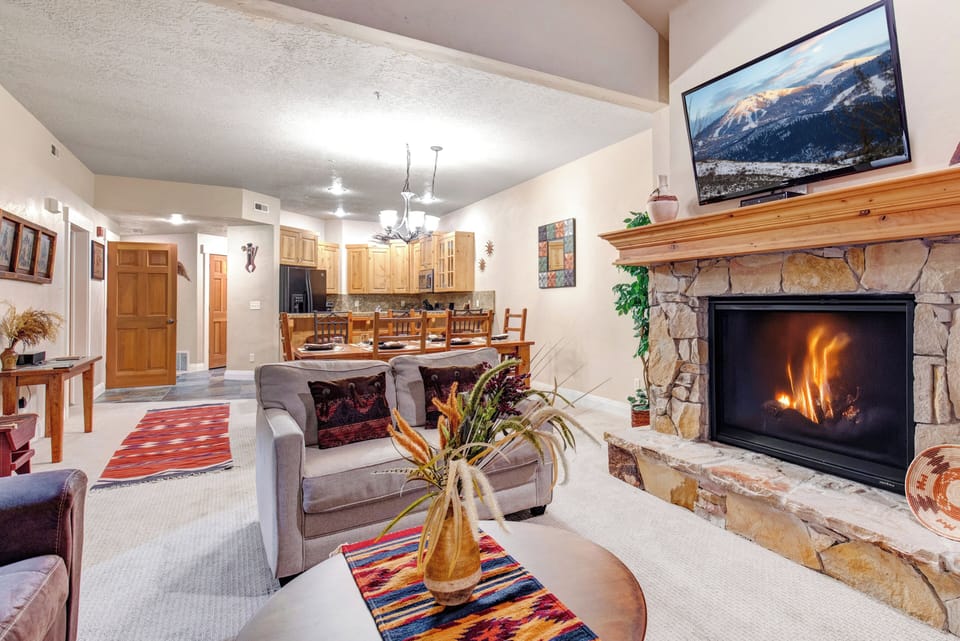 Gather around the crackling fireplace in this spacious open-plan living area, where vaulted ceilings and mountain views on the TV create a cozy yet grand retreat for your group.