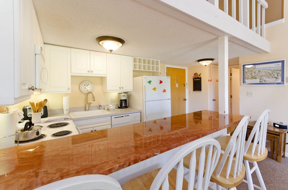 Your fully equipped kitchen features a striking marble breakfast bar where you can enjoy morning coffee while planning the day's adventures.
