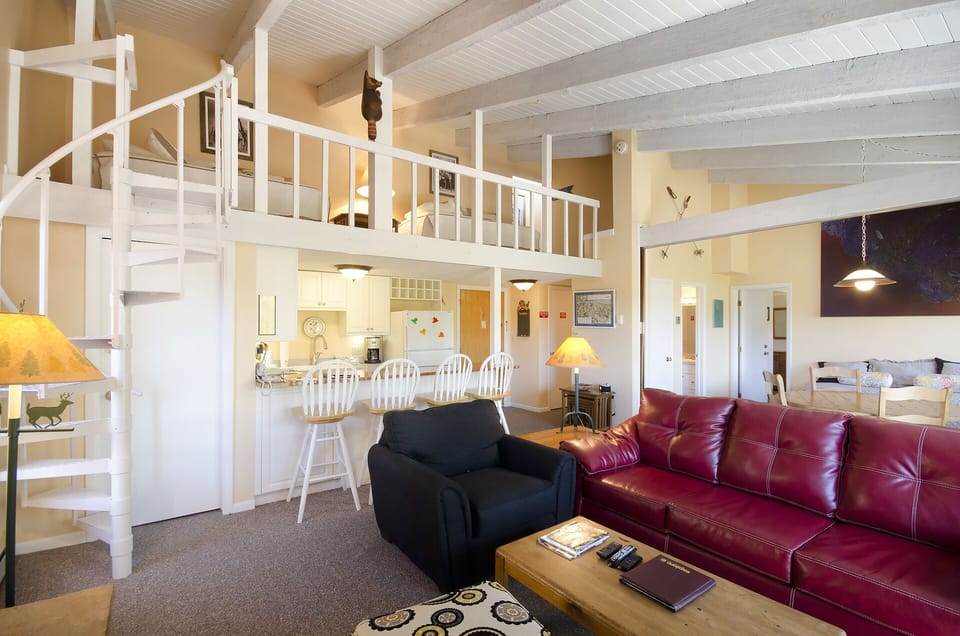 Unwind in this charming loft-style living room with soaring ceilings and warm lighting creating your perfect home away from home.