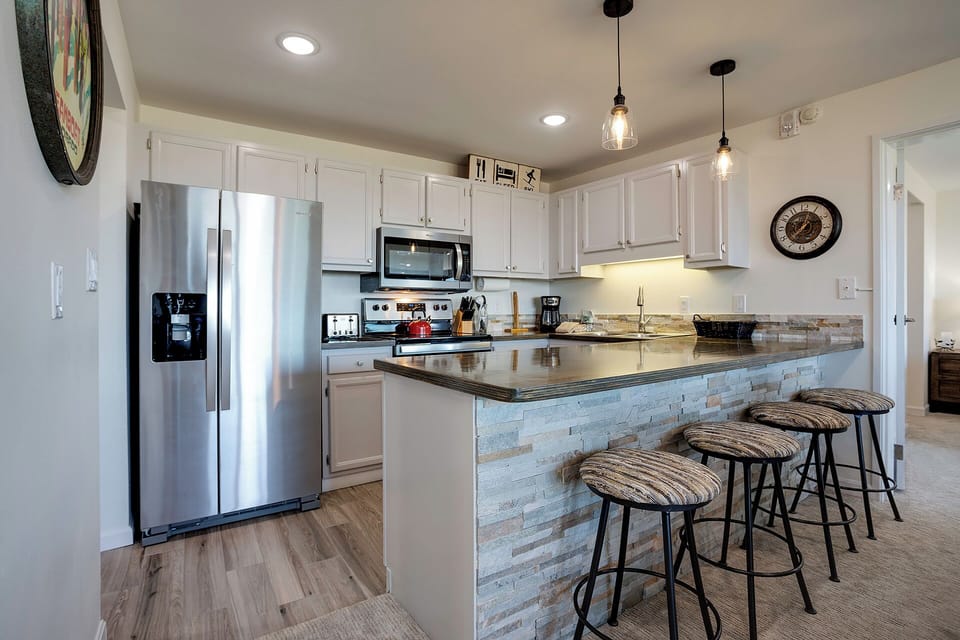 Cook memorable meals in your modern kitchen featuring granite countertops, stainless steel appliances, and a spacious breakfast bar perfect for morning coffee.