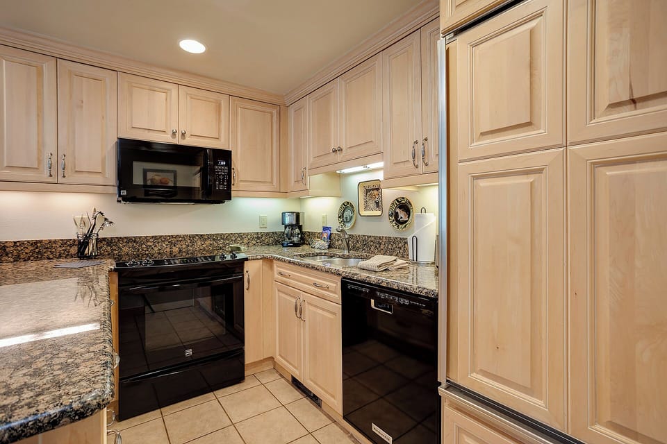 Your fully equipped kitchen features granite countertops, modern appliances, and warm wood cabinetry for all your culinary adventures.