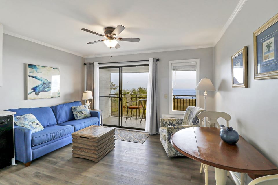 Living /dining area - Lovely decorated unit with new paint and window treatments.  Dining room table will seat 4 and there is also a queen sized sleeper sofa for additional guests.