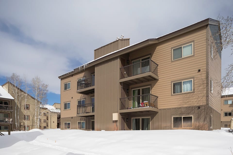 Multi-level mountain residence with private balconies in a peaceful winter setting.