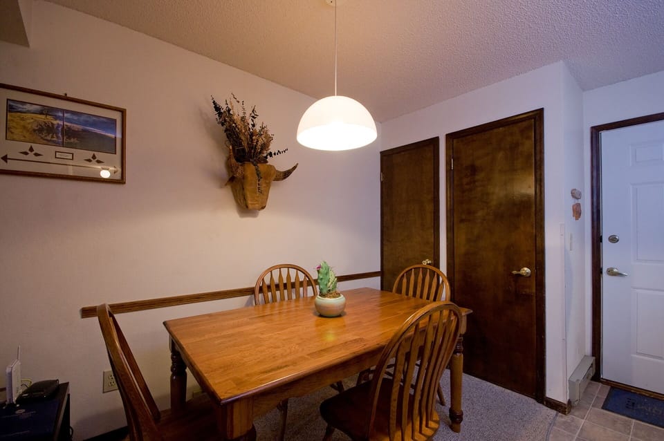 Gather around your warm wooden dining table under soft pendant lighting for memorable meals together.