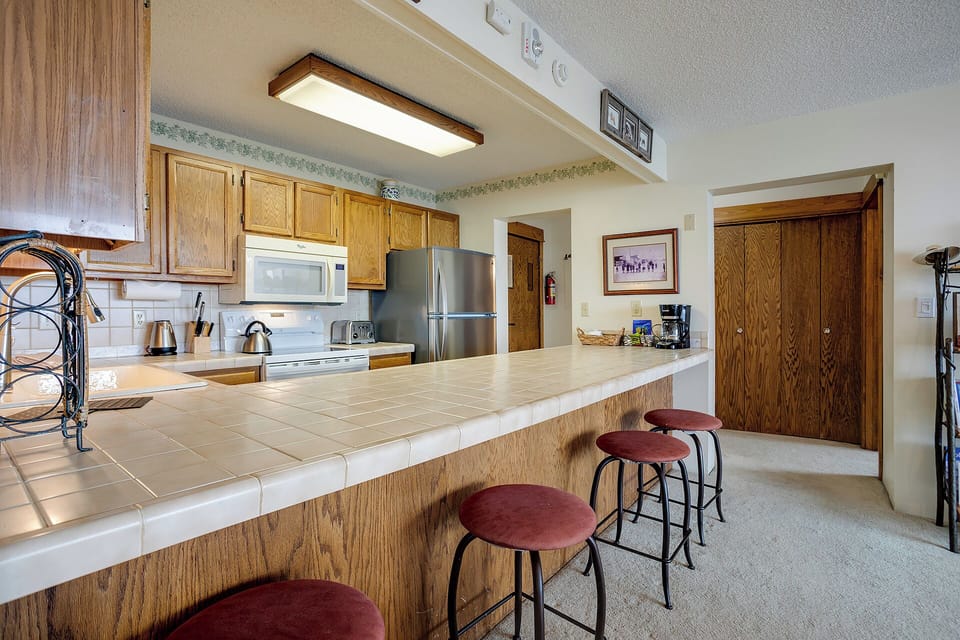 Gather around your spacious kitchen island where warm wood cabinets and modern appliances create the perfect space for morning coffee or evening conversations.
