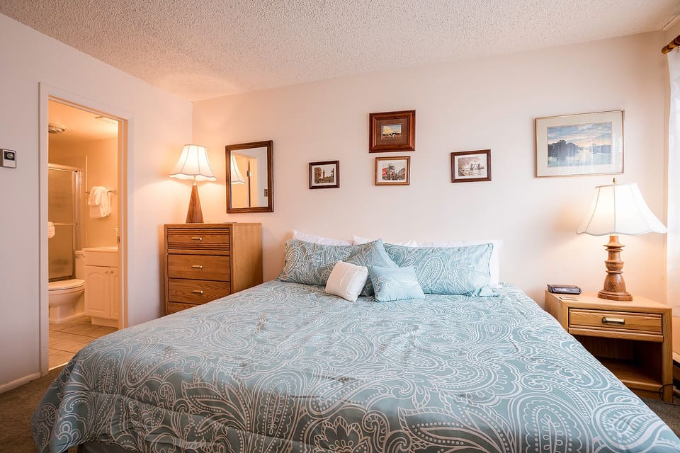 Sink into your cozy king bed with its soothing blue paisley linens. Warm lamps create the perfect reading nook while your private ensuite awaits.