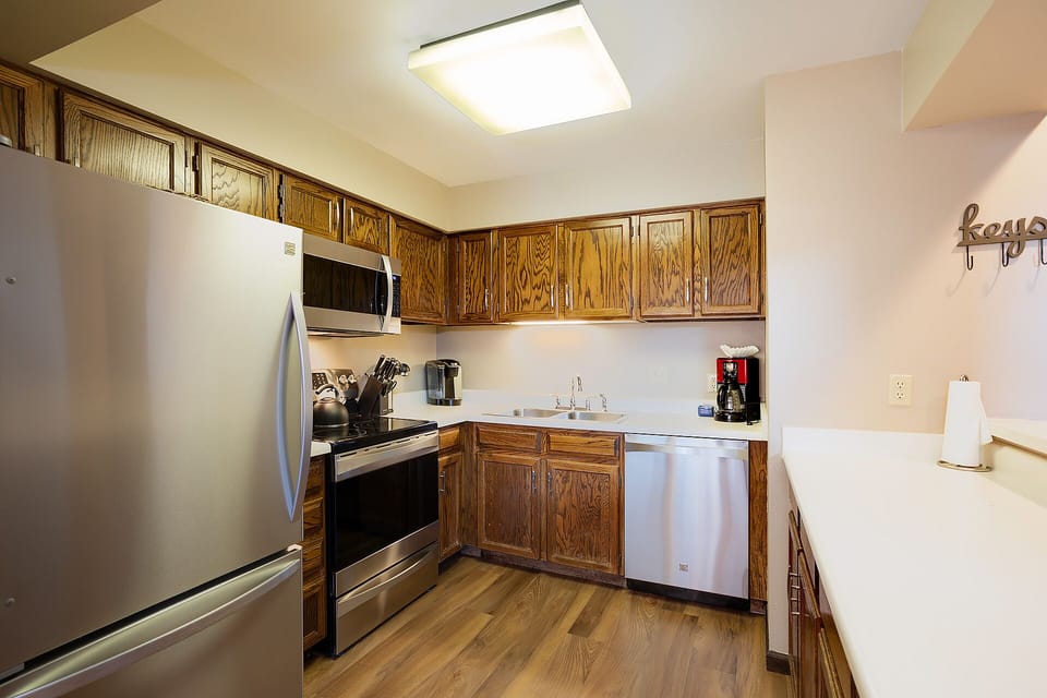 Your fully equipped kitchen features stainless steel appliances and warm wood cabinetry, perfect for preparing home-cooked meals during your stay.