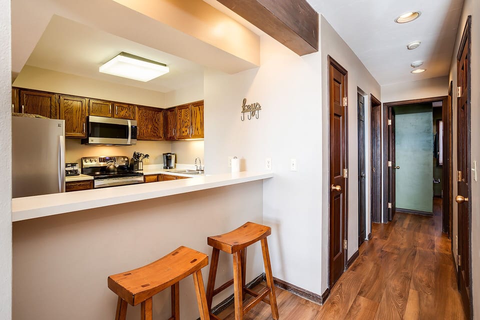 Your open kitchen features warm wood cabinets and a breakfast bar where you can sip morning coffee before exploring.