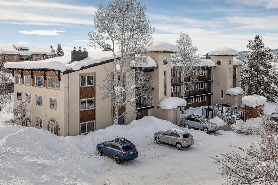 A contemporary mountain property surrounded by pristine winter snow, offering convenient parking and modern accommodations.