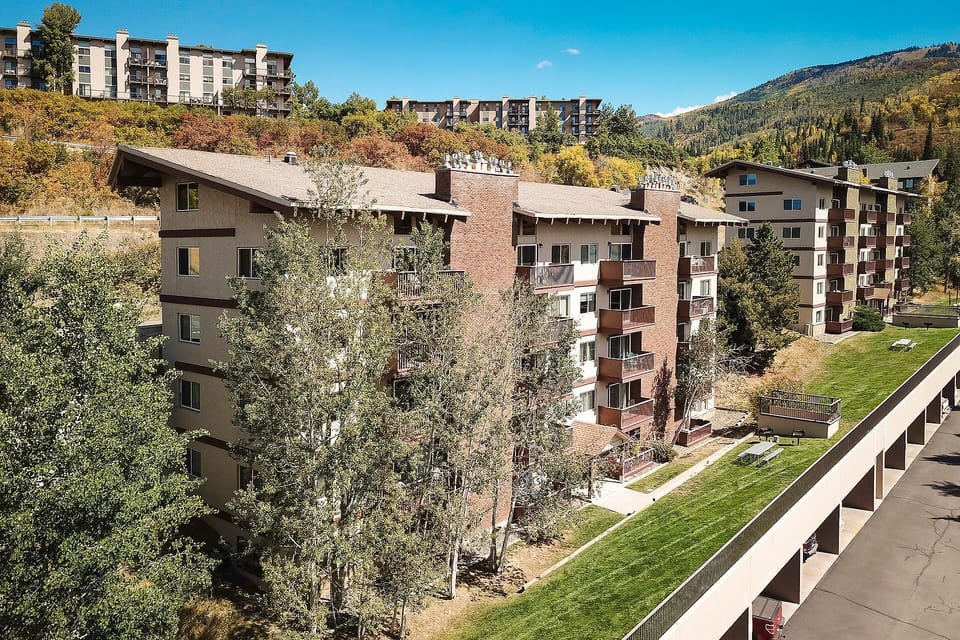 Nestled in a mountain valley setting, this property offers multi-level vacation rental buildings surrounded by mature trees, green spaces, and stunning alpine views in every direction.