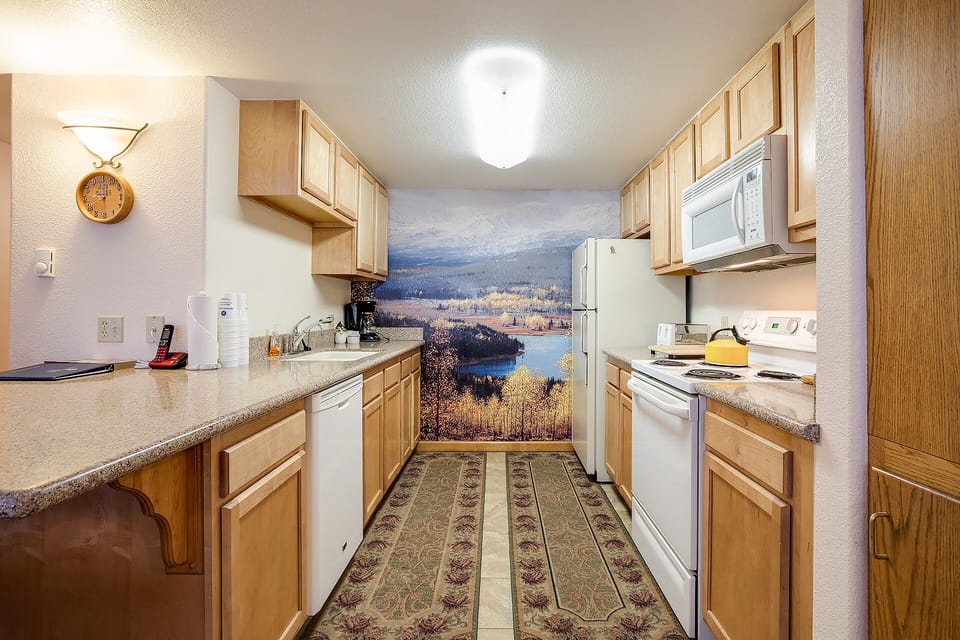 Your fully equipped kitchen awaits with everything needed to create memorable meals, featuring a stunning lake view mural that transforms cooking into inspiration.