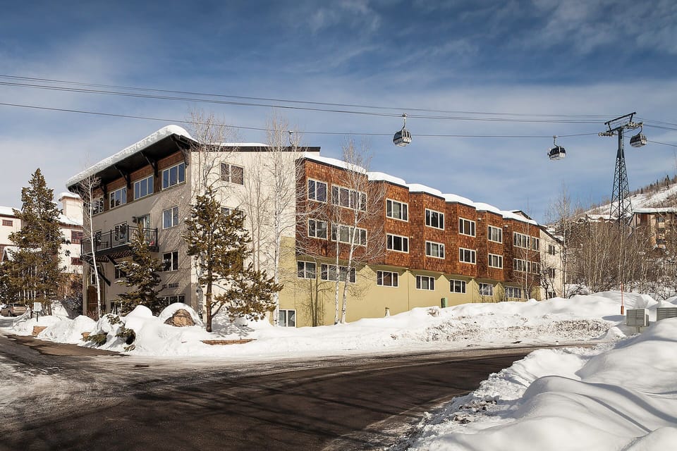Alpine lodge property nestled in snowy mountain village with ski lift access and winter adventure at your doorstep.