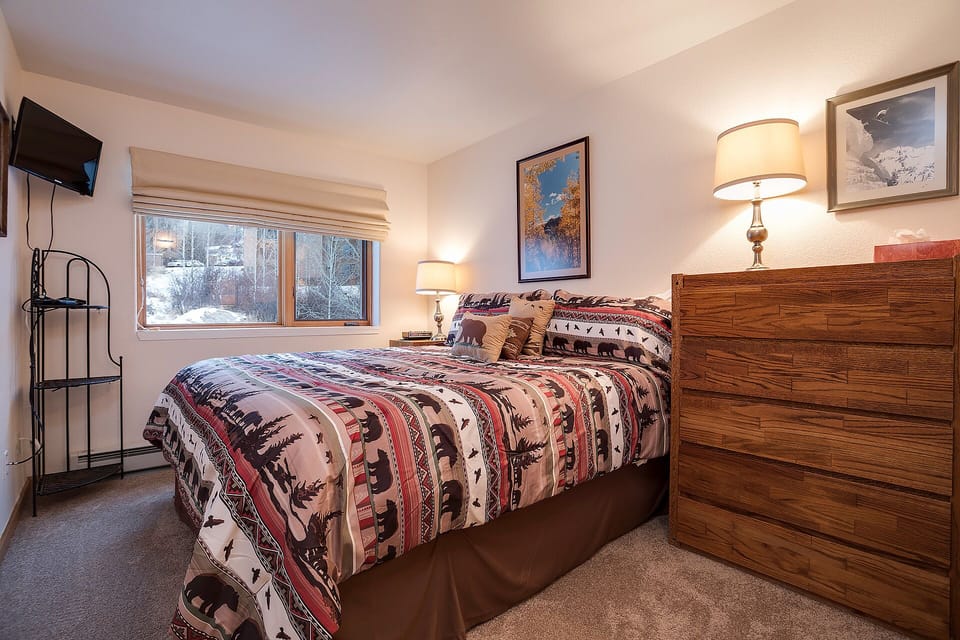 Sink into plush bedding and wake to serene snowy views from your window. Warm wood tones, soft lighting, and thoughtful touches create your perfect mountain retreat.