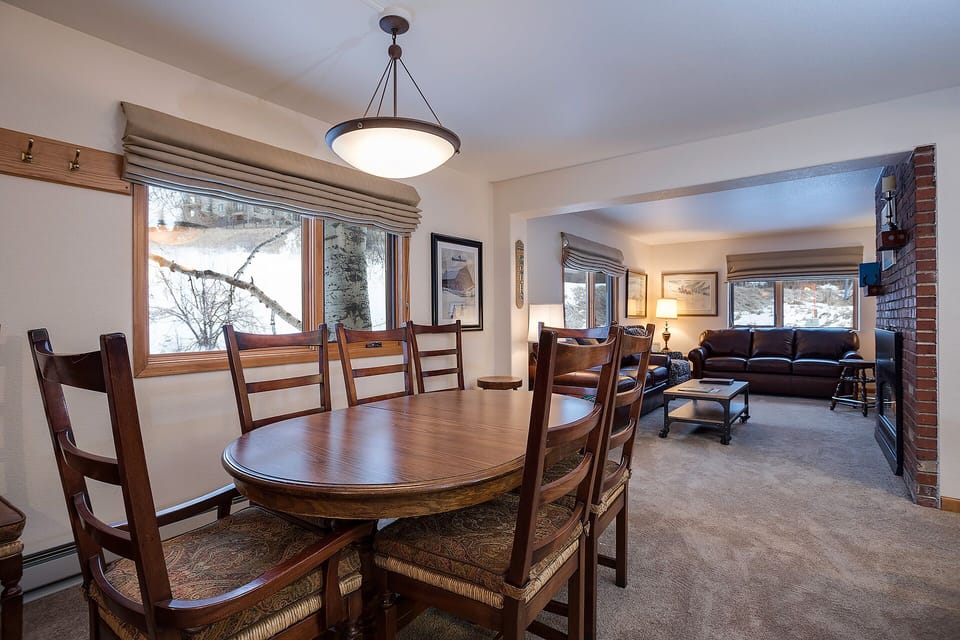 Your spacious dining area flows into a comfortable living room, perfect for gathering around the table and relaxing by the fireplace together.