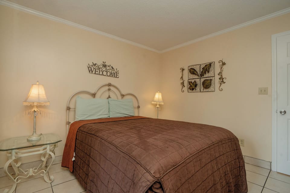 Slip into your peaceful retreat with a welcoming bedroom dressed in warm earth tones and soft bedside lighting that sets the mood for relaxation.