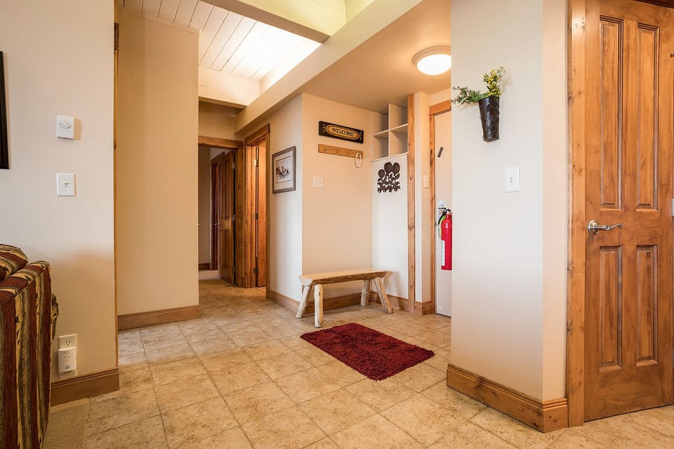 Step into your welcoming entryway with rustic wooden doors, warm lighting, and thoughtful touches that make you feel instantly at home.