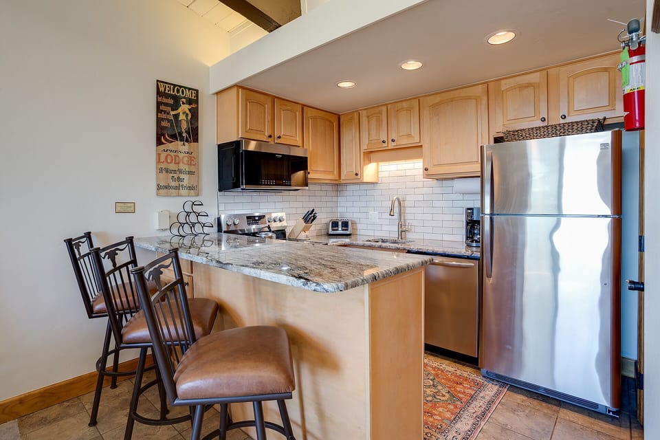 Your fully equipped kitchen awaits with granite counters, stainless appliances, and a cozy breakfast bar for morning coffee or casual meals.