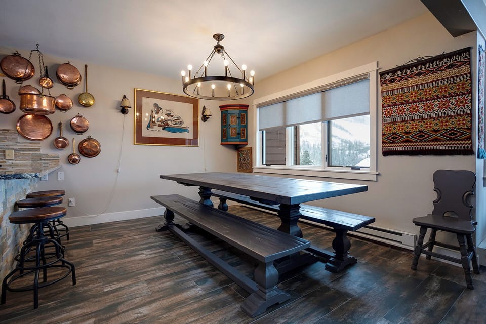 Gather around this rustic farmhouse table where copper cookware and mountain views create the perfect backdrop for your memorable meals together.
