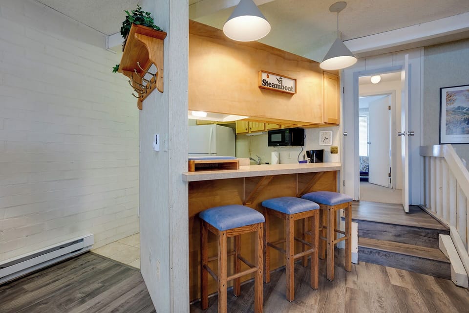 Your nautical-themed kitchen awaits with warm wood accents, breakfast bar seating, and everything needed for memorable meals together.