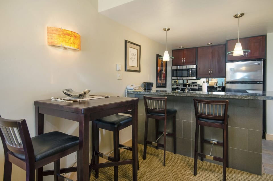 Your modern kitchen and dining area features rich wood cabinetry, granite countertops, and a breakfast bar perfect for morning coffee.