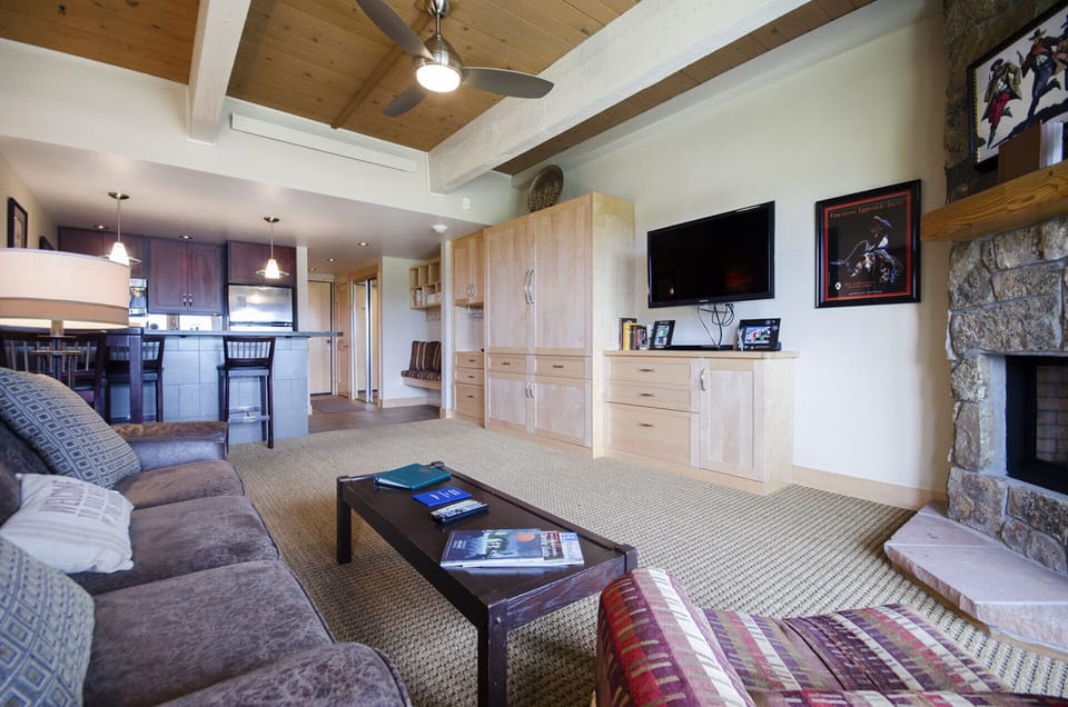Relax in your spacious living area with exposed beam ceilings and stone fireplace, perfect for cozy evenings after mountain adventures.