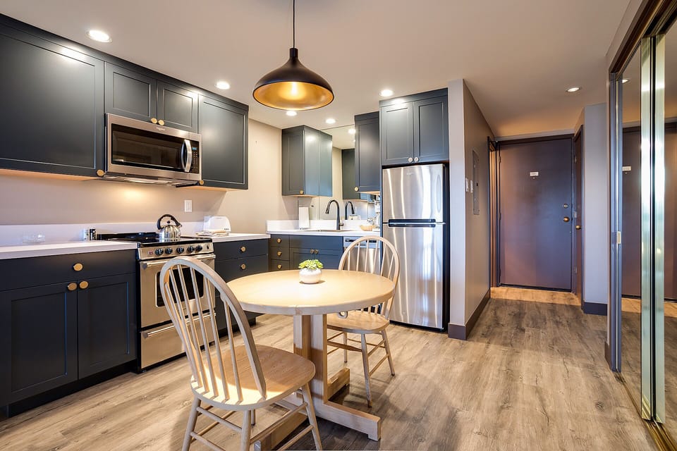 Your stylish kitchen features sleek cabinetry, stainless steel appliances, and a cozy dining nook perfect for morning coffee or evening meals together.