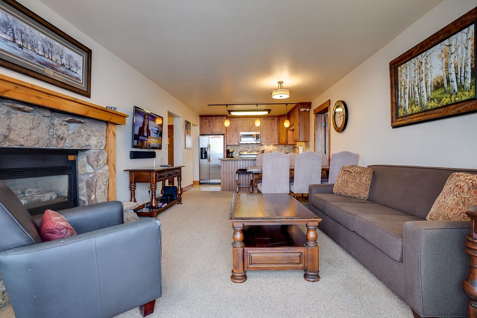 Relax by your stone fireplace in this cozy living space, complete with modern amenities and mountain artwork throughout.