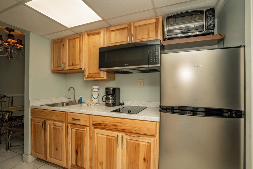 Your fully equipped kitchenette features warm wood cabinetry, stainless steel appliances, and everything you need to prepare meals during your stay.