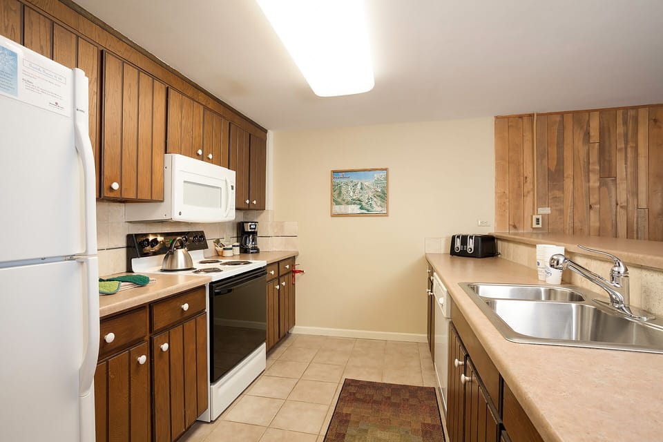 Your fully equipped kitchen awaits with warm wood cabinets, modern appliances, and everything you need to create memorable meals during your stay.